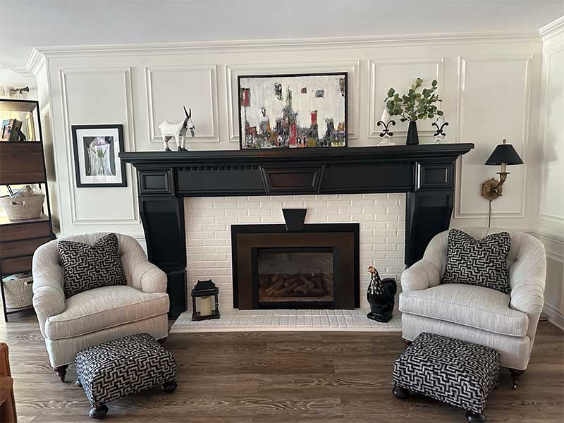 two upholstered chairs on either side of a fireplace